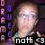 Pixelated image of a person with light skin and brown hair, wearing a teal top, against dark background with vertical text elements.