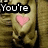 Two hands hold a pink heart against a brown textured background with partial text overlays.