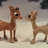 Animated sequence of two cartoon deer facing each other against a snowy background with dark shapes.