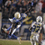 Animated sequence of football players in blue and white uniforms on a field with spectators, showing motion between frames.