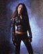 A woman in a black leather jacket and dark pants appears in five distinct poses against varied backgrounds including blue-lit smoke, textured walls, and metallic surfaces.