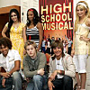 Group photo of six people posing in front of a 'HIGH SCHOOL MUSICAL' backdrop with bold yellow text on red background.