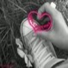 A grayscale image shows a hand forming a heart shape with fingers, overlaid by a pink heart outline with visible text inside.