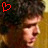 A pixelated image of a person with dark curly hair, showing two side-by-side views where the heart symbol changes from red to white.