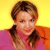 Pixelated portrait of a person with brown hair styled in two braids, wearing a pink top against a yellow background.