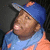 A person wearing a blue cap and light blue scarf over an orange shirt, with visible head movement across frames.