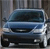 Static image of a blue sedan viewed from the front, positioned against a blurred background with vertical lines.