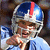 Pixelated image of a person in a blue and white football helmet with red stripe, wearing light blue jersey, holding hand near face.
