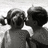 Black-and-white animation of two children in pigtails kissing, with one child's head turning from left to right across frames.