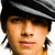 A pixelated image of a person with a dark striped headband, showing three variations: one with a neutral face, one with a heart symbol over the eyes, and one with text overlay.