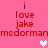 Pink background with red text reading 'i love jake' and 'medorman' repeated, featuring two white pixel hearts and one light pink pixel heart.