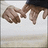 Two hands in a handshake pose, one hand slightly raised above the other against a light background.