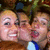 Three people pose together in a pixelated image with one person covering their mouth with a hand, wearing a blue and white shirt.