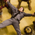A person in a gray suit with a black belt lies on a yellow background, arms and legs spread wide in a star-like pose.