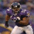 A pixelated football player in purple and white uniform holding a ball, next to a stylized bird logo with blue, yellow, and white colors on dark background.