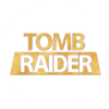 Circular white icon with golden-brown 'TOMB RAIDER' text; 'TOMB' in uppercase sans-serif above a rectangular banner containing 'RAIDER' in larger uppercase sans-serif.