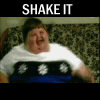 A person in a white shirt with blue and black horizontal stripes sits on a patterned couch, repeatedly shaking their body while the text "SHAKE IT" appears above each frame.