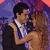 Two people dancing closely in formal attire against a purple and red background with text below.