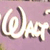 Pixelated white text '@Lapt' on a light purple background with subtle brown and beige accents.