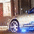 Animated silver and blue sports car with visible reflections on a city street background.