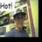 Pixelated static image shows a figure with dark hair and brown skin holding an object, set against a yellowish background with partial text reading 'Hot' in the top-left corner.