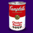 Static pixelated image of a red and white soup can with partial text, green circular emblem, and vegetable illustrations on a dark purple background.