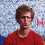 A person in a red shirt appears across with changing text overlays on a pixelated background