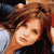 Pixelated static image of a person with brown hair and light skin, wearing dark clothing against a blurred background.