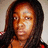 Pixelated portrait of a person with long dark hair, light brown skin tone, and visible facial features including eyes, nose, mouth, and forehead.