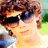 Pixelated image of a person with brown curly hair wearing dark sunglasses, positioned next to pixelated text reading "yo i'm so hot" and "just like nick j is a tamale off da chair".