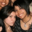 Two people in a close-up photo with dark hair and black clothing, surrounded by text elements on a black background.