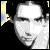 Pixelated grayscale portrait of a person with a blank expression, featuring a bright white forehead and nose against a black background with yellow and blue corner accents.