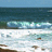 Animated contact sheet of a beach wave scene with yellow text lyrics displayed across multiple frames showing sequential motion of ocean waves crashing on shore.