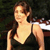 Pixelated image of a person with light skin wearing a dark sleeveless top, standing against a dark background with a white horizontal element on the right.