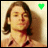 A 48x48 pixel buddy icon showing a person with long brown hair in two frames, one with a green heart symbol and the other with a black heart symbol above their head.