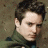 A pixelated image of a person with dark hair and light skin against a brown background, next to green text reading 'OriginalIcons.com' on a solid green backdrop.