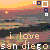 Pixelated sunset scene over water with 'i love san diego' text and four square icons in top corners, two white and two dark blue.