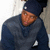 A person wearing a dark beanie and gray hoodie appears in four showing slight head and body movement against a light background