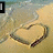 A beach scene with a heart drawn in sand, showing animation changes to the top-left corner and bottom text overlay.