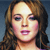 Pixelated close-up of a person with light brown hair, pink lips, and visible eyes against a blue background.