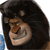 Pixelated cartoon character with dark brown hair, light brown face, and wide grin showing teeth, set against a white background with blue and gray elements.