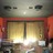 Pixelated image of a theater entrance with red trim and illuminated interior, viewed from a low angle.