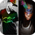 A pixelated image shows two figures side-by-side; one wears a green and black outfit with red accents, the other has dark hair and light clothing against a dark background.