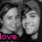 Two grayscale faces in close-up, side-by-side with a black background and pink 'love.' text at bottom left.
