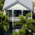 Pixelated static image of a two-story house with a gabled roof, surrounded by green foliage, viewed from a low angle.