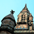 Pixelated image of two domed structures with a cross on the left dome against a light blue background.
