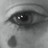 A grayscale close-up of a human eye with a single teardrop falling below, rendered in pixelated style.
