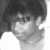 Black-and-white pixelated image of a person with dark hair, visible ear, and light-colored clothing against a white background.