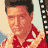 Pixelated static image of a person in red attire with dark hair and visible facial features against a light background.
