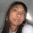 Pixelated static image of a person with long dark hair, light skin, and a neutral expression against a gray background.